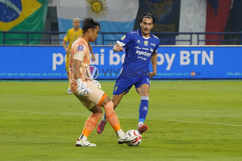 Andrew Jung berusaha menjegal Ernando Ari di laga Persib Bandung versus Persebaya Surabayam
