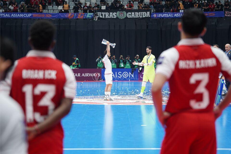 Para pemain Timnas Futsal Indonesia menyaksikan prosesi angkat piala Timnas Futsal Iran.